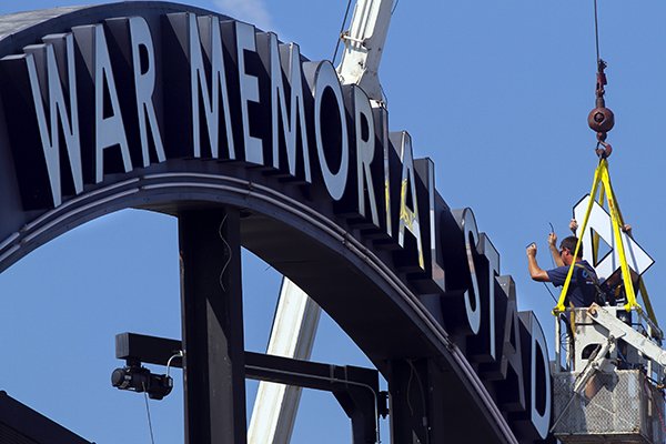 Workers replace lightbulbs inside a sign at War Memorial Stadium on Friday, Sept. 6, 2013 in Little Rock. 
