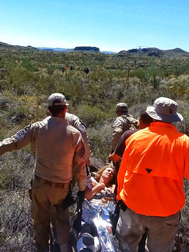 Texas game wardens and TEXSAR search-and-rescue volunteers carry Cathy Frye from her mesquite
tree to the Border Patrol helicopter that airlifted her out.