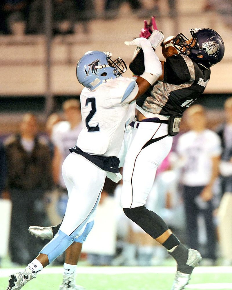 STAFF PHOTO ANDY SHUPE - C.J. O'Grady, right, of Fayetteville reaches to make a catch while under pressure from Austin Henderson (2) of Springdale Har-Ber during the first half Friday, Oct. 17, 2014, at Harmon Stadium in Fayetteville.