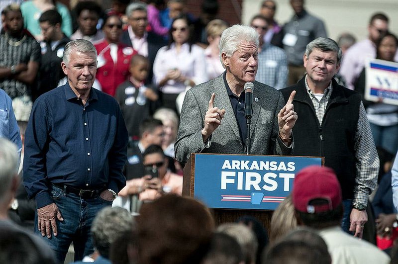 Staff photo by Jerry Habraken
Democratic candidates James Lee Witt, left, and Mike Ross, right, watch former President Bill Clinton speak to the crowd during a rally at the train depot in his hometown of Hope, Ark. Saturday morning. Clinton praised all of the democratic candidates up for election and touched on topics such as the Ebola and healthcare. 