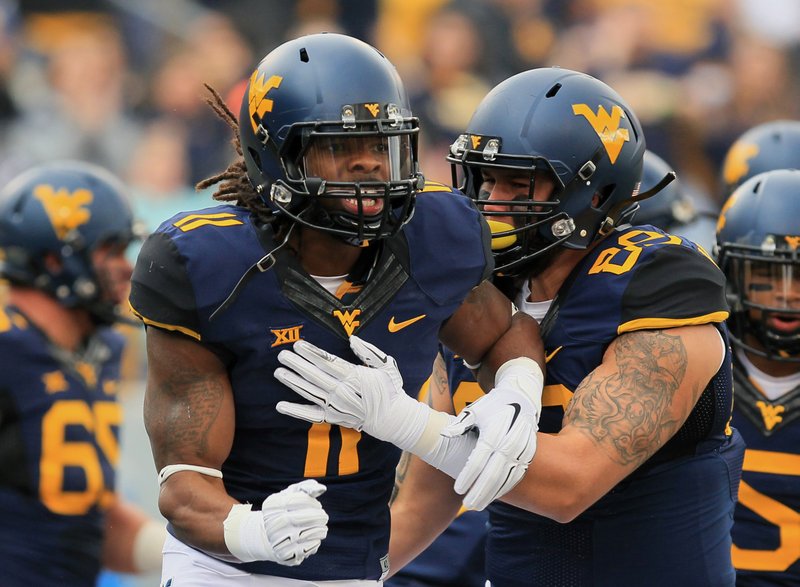 West Virginia's Kevin White (11) celebrates a touchdown with Dustin Garrison (29) during the first quarter of an NCAA college football game against Baylor in Morgantown, W.Va., Saturday, Oct. 18, 2014. West Virginia won 41-27. 