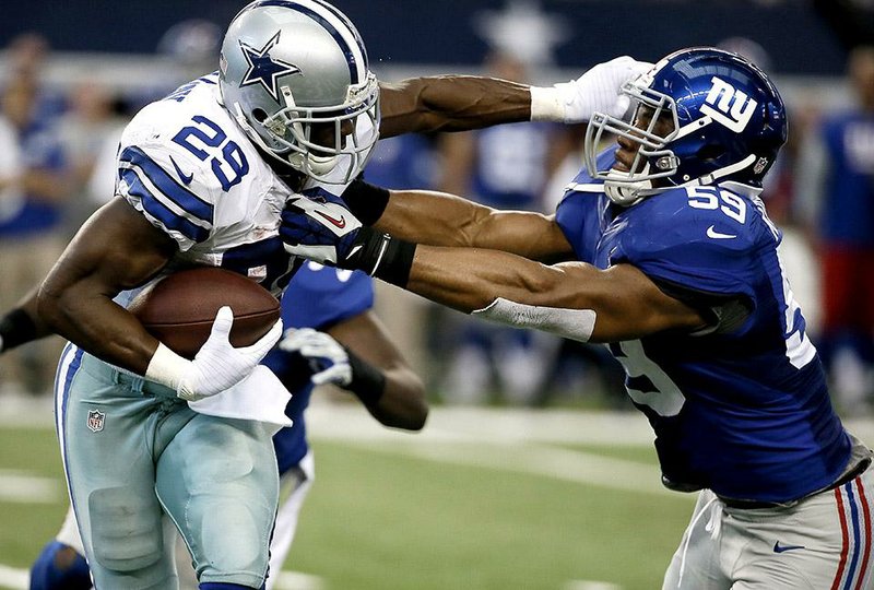 Dallas Cowboys' DeMarco Murray (29) fights off a tackle attempt by New York Giants' Devon Kennard (59) during the first half of an NFL football game, Sunday, Oct. 19, 2014, in Arlington, Texas. (AP Photo/Brandon Wade)