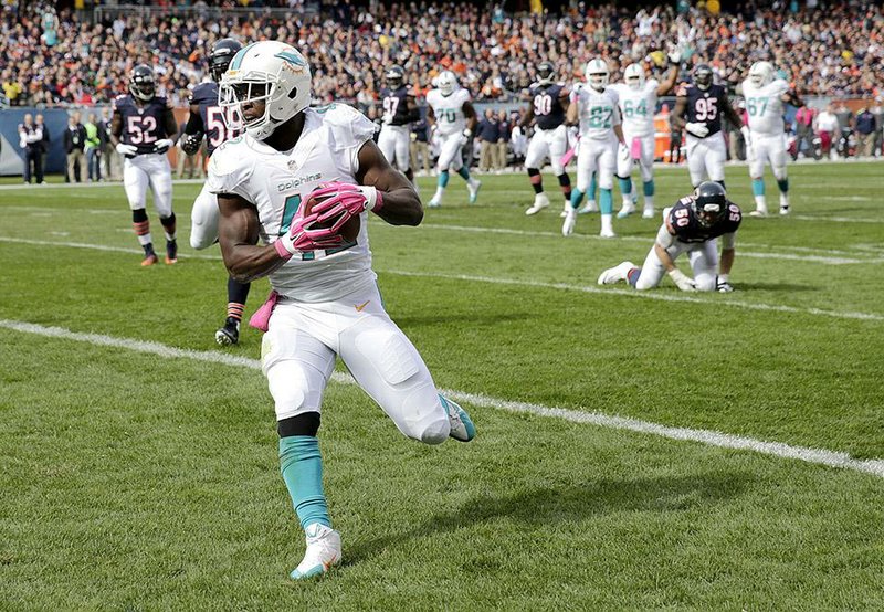 Miami Dolphins tight end Charles Clay (42) runs into the end zone for a touchdown during the first half of an NFL football game against the Chicago Bears Sunday, Oct. 19, 2014 in Chicago. (AP Photo/Charles Rex Arbogast)