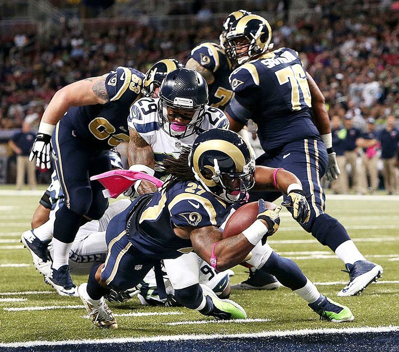 St. Louis Rams running back Tre Mason dives into the end zone past Seattle Seahawks free safety Earl Thomas (29) as he scores on a touchdown run in first quarter action during an NFL football game Sunday, Oct. 19, 2014, at the Edward Jones Dome in St. Louis. (AP Photo/St. Louis Post-Dispatch, Chris Lee)