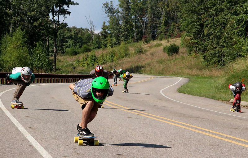 Special to the Democrat-Gazette/BOB ROBINSON
Chandler Benton (Fayetteville, green helmet) joins
members of NoCoast-Skate who traveled from around the region Sept. 20 to run downhill on Shepherd Springs Road outside Lake Fort Smith State Park. 