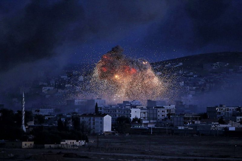 Smoke and flames from an airstrike by the US-led coalition rise in Kobani, Syria, as seen from a hilltop on the outskirts of Suruc, at the Turkey-Syria border, Monday, Oct. 20, 2014 Kobani, also known as Ayn Arab, and its surrounding areas, has been under assault by extremists of the Islamic State group since mid-September and is being defended by Kurdish fighters. (AP Photo/Lefteris Pitarakis)