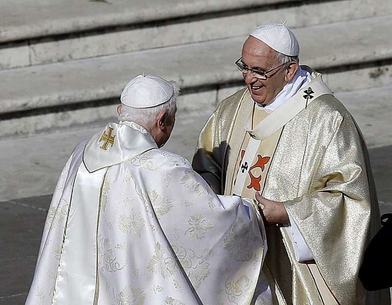 Pope Emeritus Benedict XVI, left, greets Pope Francis prior to the start of the beatification ceremony of Pope Paul VI and a mass for the closing of a two-week synod on family issues, in Saint Peter's Square at the Vatican, Sunday, Oct. 19, 2014. (AP Photo/Gregorio Borgia)