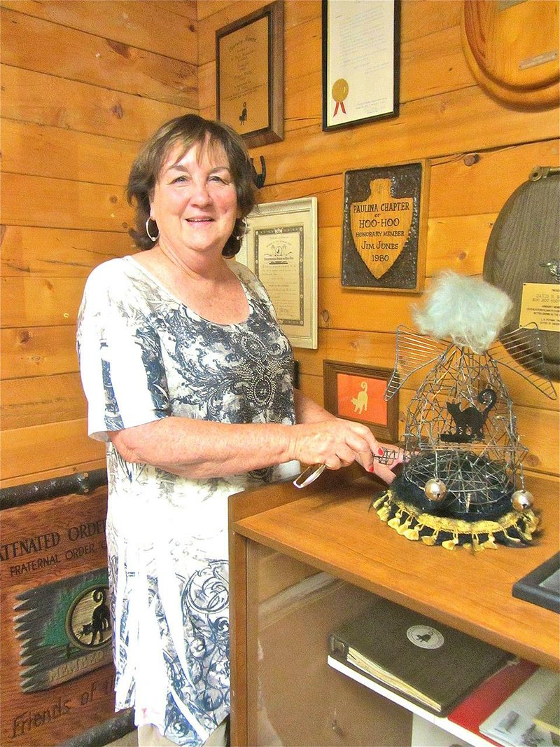Beth Thomas, executive secretary of Hoo-Hoo International, explains a whimsical piece of headgear at the fraternal organization’s headquarters and museum in Gurdon.