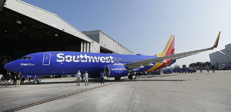 A Southwest Airlines plane sporting the newly unveiled paint color scheme sits outside a hanger after an event at Love Field Monday, Sept. 8, 2014, in Dallas. The change comes in a year during which 43-year-old Southwest has begun international flights, expanded in New York and Washington, and is freed from longtime government limits on its Dallas schedule. (AP Photo/LM Otero)