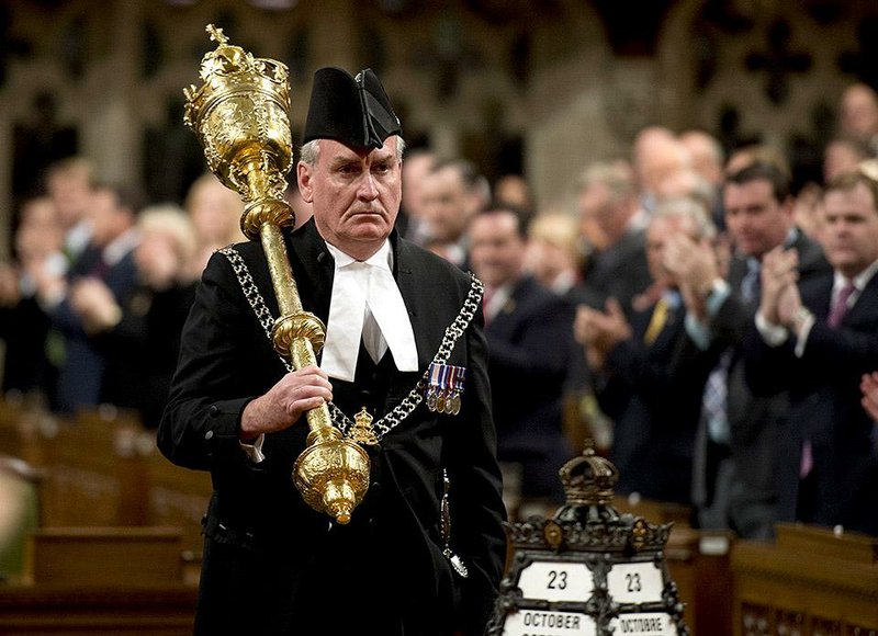 The Sergeant-at-Arms Kevin Vickers receives a standing ovation as he enters the House of Commons Thursday, Oct.  23, 2014 in Ottawa. Vickers was among those who opened fire on Michael Zehaf Bibeau, who stormed Parliament Hill on Wednesday. (AP Photo/The Canadian Press, Adrian Wyld )