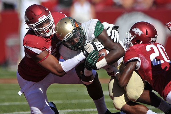 Arkansas defenders Deatrich Wise Jr., left, and De'Andre Coley bring down UAB running back Jordan Howard during a game Saturday, Oct. 25, 2014 at Razorback Stadium in Fayetteville. 