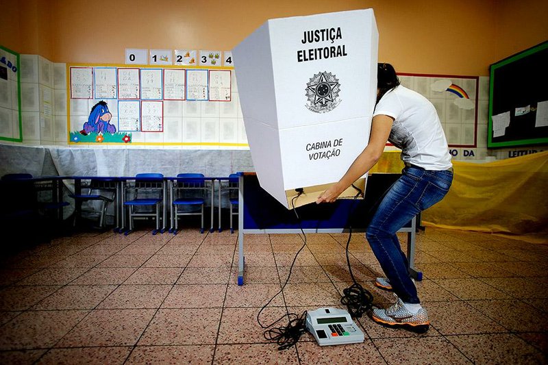 An election worker assembles a voting station Saturday at a school in Brasilia, Brazil, in preparation for today’s presidential election.