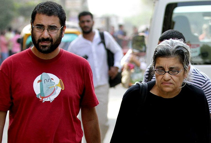 Egypt’s most prominent activist Alaa Abdel-Fattah, left, walks with his mother Laila Soueif, a university professor who is an also an activist, outside a court that convicted 23 activists of staging an illegal demonstration and sentenced them each to three years in jail, in Cairo, Egypt, Sunday, Oct. 26, 2014. Among the 23 is Sanaa Seif, who hails from a family of longtime rights campaigners, including her late father Ahmed Seif al-Dawla and brother Alaa Abdel-Fattah. Another defendant is Yara Sallam, a prominent rights lawyer. Sunday's verdicts, which can be appealed, comes at a time when Egypt is swept by nationalist sentiments following a dramatic surge in attacks blamed on Islamic militants on troops and security forces in the Sinai Peninsula while witnessing a smear campaign targeting many of the secular pro-democracy campaigners behind the 2011 uprising. (AP Photo/Hussein Tallal)