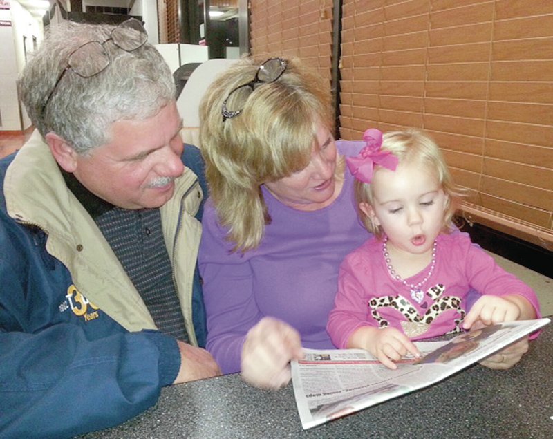 Submitted Photo Tenley, 2, is surprised when her grandparents, Keith and Georgia Harper of Gentry, showed her a photograph of herself in the Eagle Observer taken when she was painting a pumpkin at Gentry&#8217;s fall festival on Oct. 12.