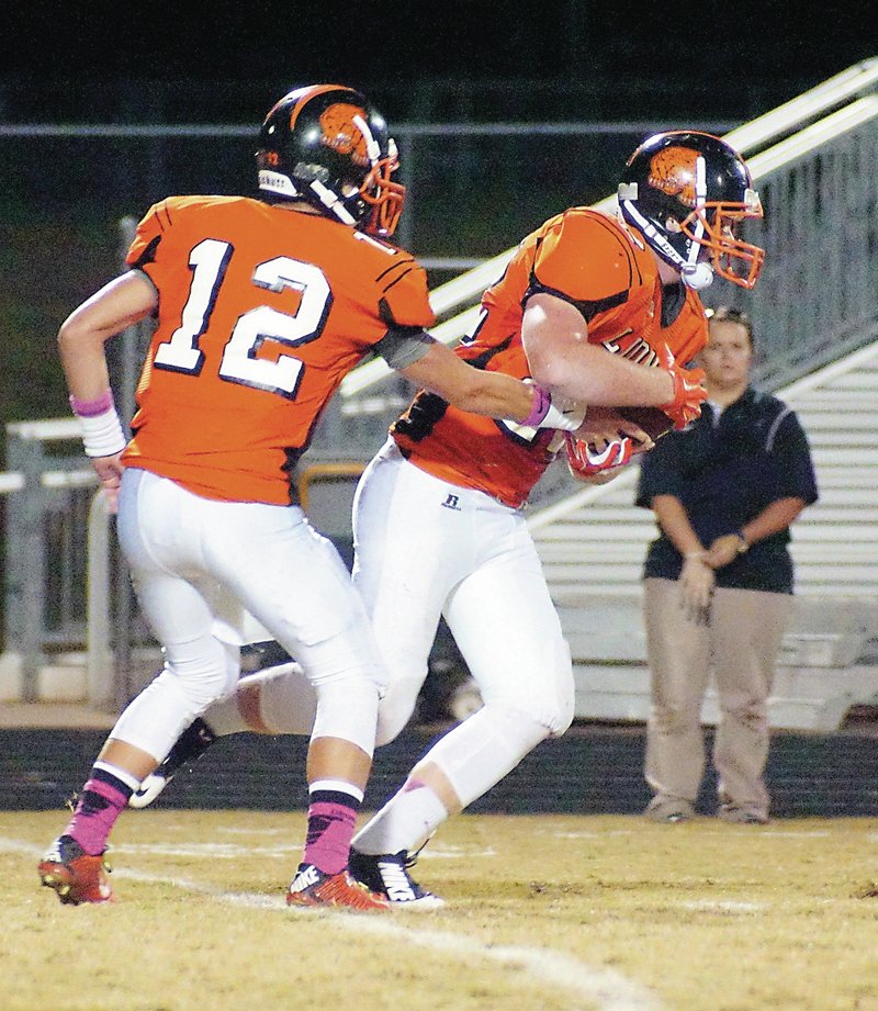 Gravette quarterback Bryce Moorman hands off the ball to Jackson Soule during play against Huntsville on Friday night.