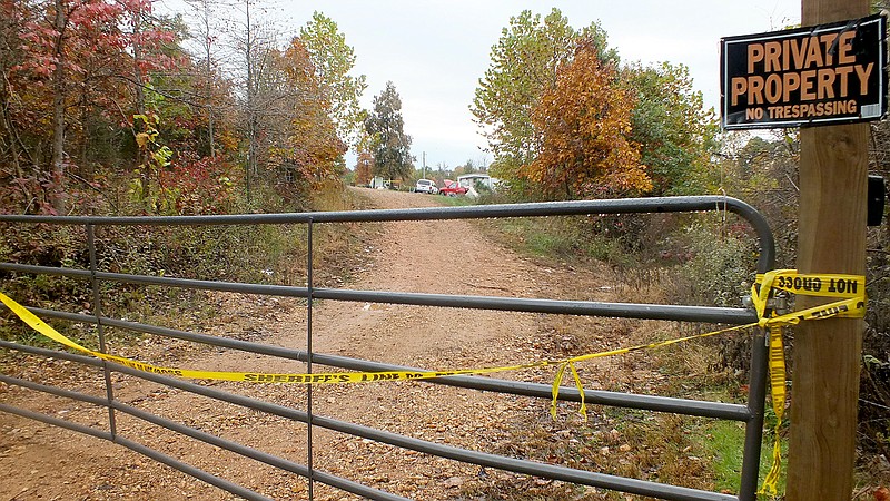 TIMES photograph by Annette Beard Yellow crime-scene tape across a gate is not for Halloween but was placed there by law enforcement authorities last week. The residence, at 222 Donnely Lane, Powell, Mo., is the site of a home invasion that left one man dead.