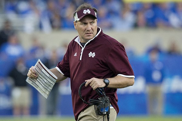 Mississippi State head coach Dan Mullen checks on the condition of an injured player during the second half of an NCAA college football game against Kentucky at Commonwealth Stadium in Lexington, Ky., Saturday, Oct. 25, 2014. Mississippi State beat Kentucky 45-31. (AP Photo/David Stephenson)