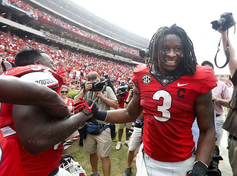  In this Sept. 27, 2014, file photo, Georgia running back Todd Gurley (3) celebrates with linebacker Amarlo Herrera (52) after an NCAA college football game against Tennessee in Athens, Ga. No. 9 Georgia continues to await word from the NCAA on the status of star tailback Todd Gurley for Saturday's game against Florida. Georgia has asked for the reinstatement of Gurley, who has acknowledged mistakes and has been suspended the last two games for an alleged violation of NCAA rules. 