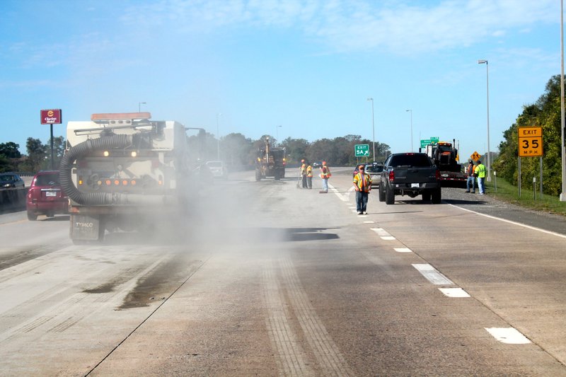 Highway crews clean a gravel spill Thursday morning on Interstate 630 in Little Rock.