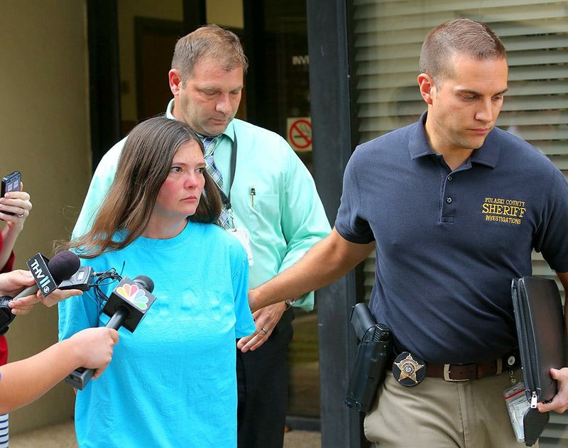 10/30/14
Arkansas Democrat-Gazette/STEPHEN B. THORNTON
Crystal Lowery, 41, left, wife of murder suspect Aaron Lewis is led away from the Pulaski County Sheriff's office Thursday afternoon in Little Rock. Lowery was charged with capital murder and kidnapping in the death of realtor Beverly Carter.