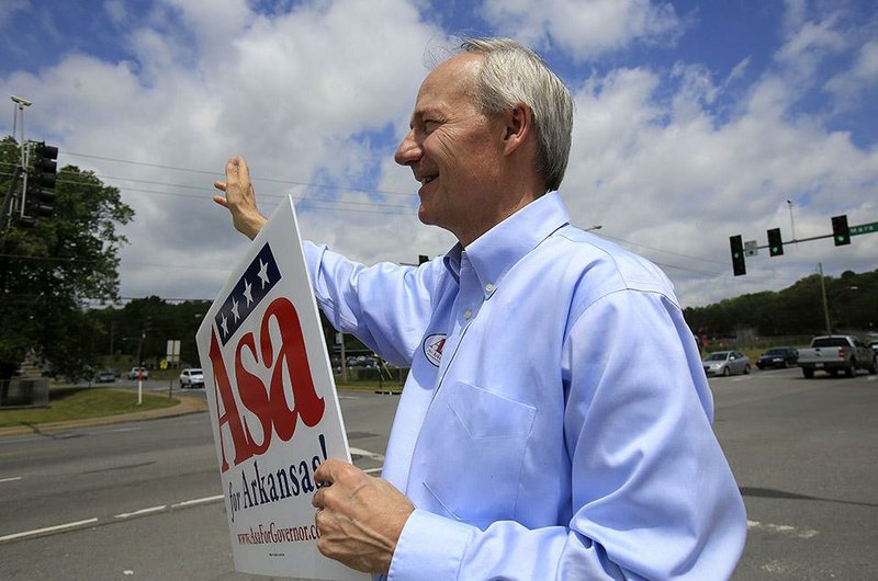 Arkansas Democrat-Gazette/STATON BREIDENTHAL --5/20/14-- Asa Hutchinson waves to motorists as he campaigns on Tuesday morning in Little Rock. Hutchinson is seeking the Republican nomination for  governor.