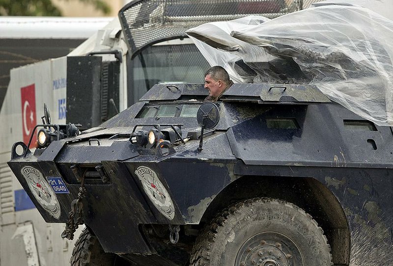 A Turkish armored vehicle arrives at a staging area where Iraqi Kurdish peshmerga fighters are stationed on the outskirts of Suruc, near the Turkey-Syria border, across from the Syrian town of Kobani, Thursday, Oct. 30, 2014. Ten Iraqi peshmerga fighters entered the northern Syrian border town of Kobani, also known as Ayn Arab, crossing over from Turkey on Thursday, the first from among a group of 150 Kurdish troops on their way into the embattled city.(AP Photo/Vadim Ghirda)