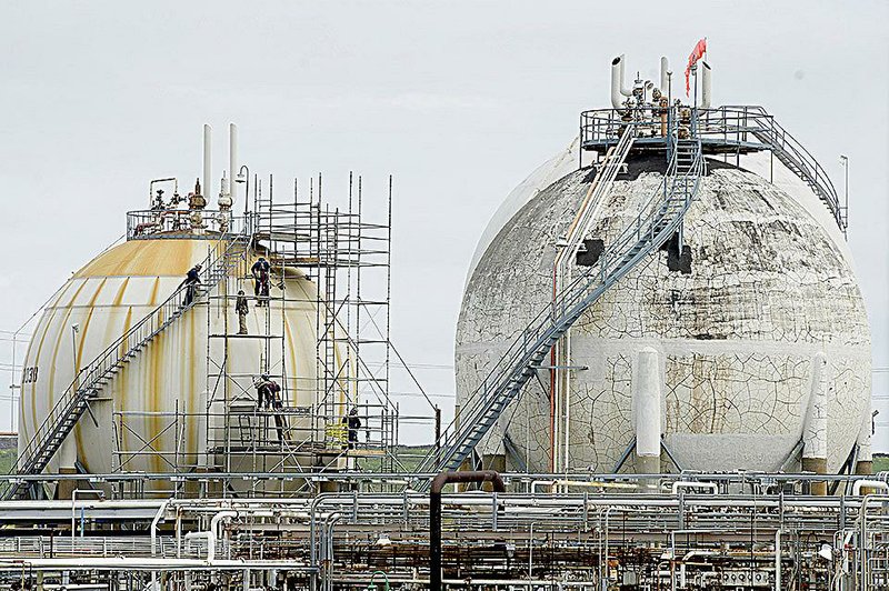 Bloomberg Photo Service 'Best of the Week': Employees work on a storage tank inside the Chevron Corp. Richmond Refinery in Richmond, California, U.S., on Thursday, April 24, 2014. Chevron Corp. hopes to gain city approval to finish hydrogen plant at the Richmond refinery in June or July. Photographer: David Paul Morris/Bloomberg