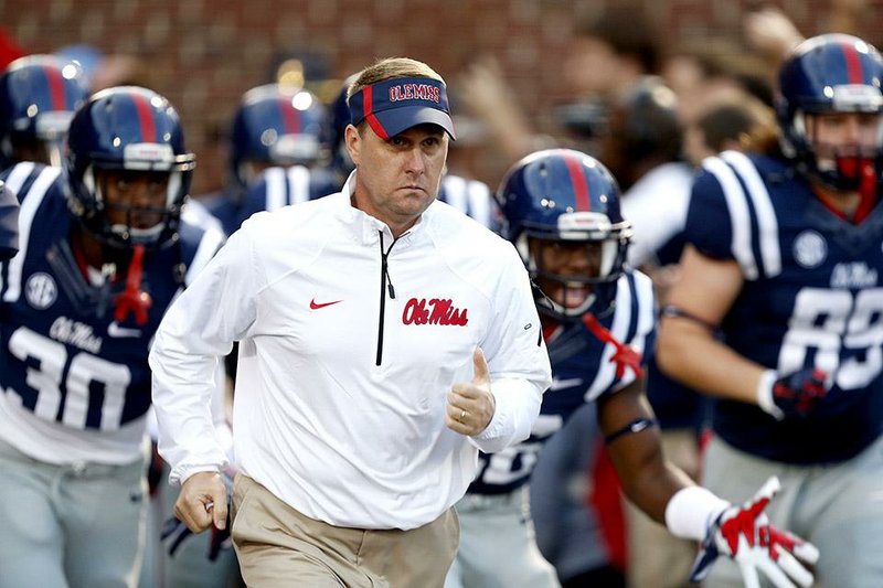 Mississippi coach Hugh Freeze run onto the field before an NCAA college football game against Tennessee in Oxford, Miss., Saturday, Oct. 18, 2014. (AP Photo/Rogelio V. Solis)