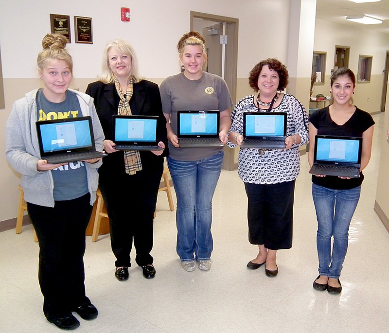 Janelle Jessen/Siloam Sunday Ten Chromebook computers, purchased with money raised during the 2013 Friends of the Main Street Academy fundraiser, arrived on Monday. Pictured holding some of the Chromebooks are student Alexus Herling, adopter board member Gina VanDyck, student Breanna Green, principal Michele Markovich, and student Ester Gonzalez.