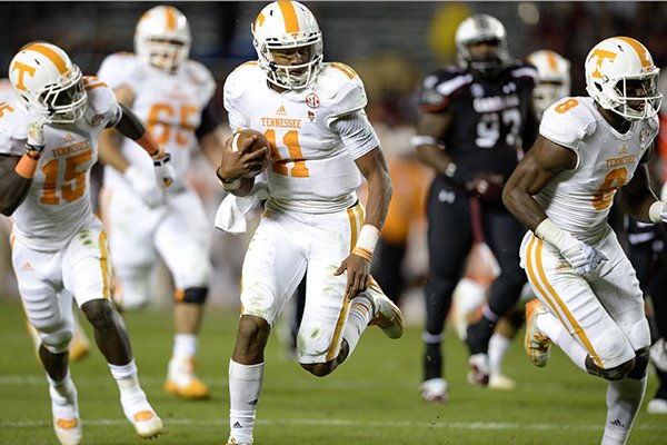 Tennessee quarterback Joshua Dobbs (11) takes off on a fourth-down play, with seconds left on the clock, to score a 36-yard touchdown during the first half of an NCAA college football game against South Carolina in Columbia, S.C., Saturday, Nov. 1, 2014. (AP Photo/ Richard Shiro)