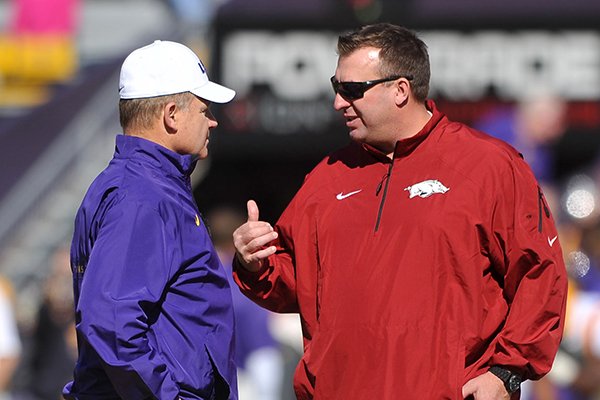 Arkansas coach Bret Bielema, right, talks with LSU coach Les Miles prior to a game Friday, Nov. 29, 2013 at Tiger Stadium in Baton Rouge, La. 