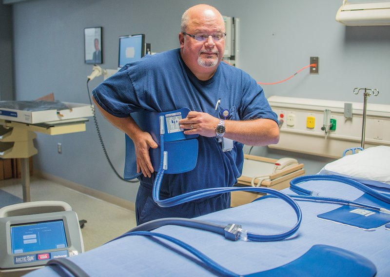 Lee Lessenberry, emergency department coordinator at Saline Memorial Hosptial in Benton, shows how doctors at the facility use chilling pads on a cooling unit manufactured by Arctic Sun. The cooling unit allows medical staff to bring the temperature of a trauma patient down to lessen damage that can occur after quickly resuscitating a patient following a stroke or heart attack. Recently, the hospital’s staff used the core-chilling technique on Salem resident Randy Jones to increase his chances of survival and decrease his chances of brain-cell death.