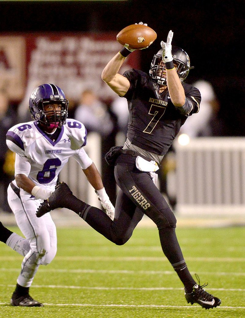 STAFF PHOTO BEN GOFF  @NWABenGoff -- 11/07/14 Ben Barron, Bentonville wide receiver, catches a pass under pressure from Fayetteville's Colby Sigears during the second quarter of the game in Bentonville's Tiger Stadium on Friday Nov. 7, 2014. 