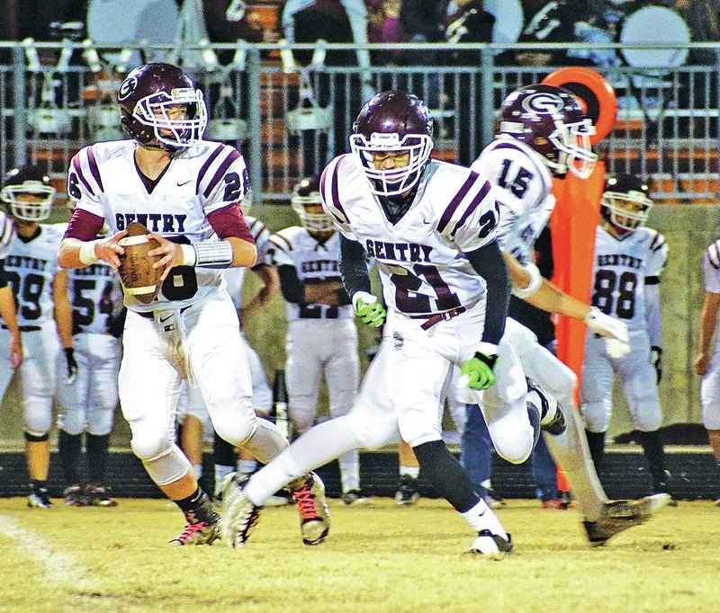 Staff Photo Randy Moll Kevin Easter, Gentry quarterback, looks downfield Friday for a receiver while Bryan Harris and Dakota Smith draw defenders away against Gravette at Lion Stadium in Gravette.