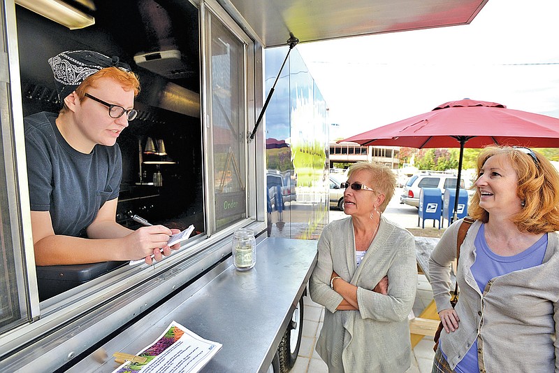 STAFF PHOTO BEN GOFF &#8226; @NWABenGoff Allison Osburn, from left, takes orders from Margie Johns and Pam Henderson at the TrickDilly food truck on North Main Street in Bentonville.