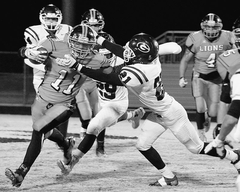 Photo by Randy Moll Gravette running back Cedric Duarte breaks tackles of Gentry&#8217;s Bryan Harris (#21) and Sky Crowell (#29) to carry the ball farther down field for the Lions during play in Gravette on Friday.