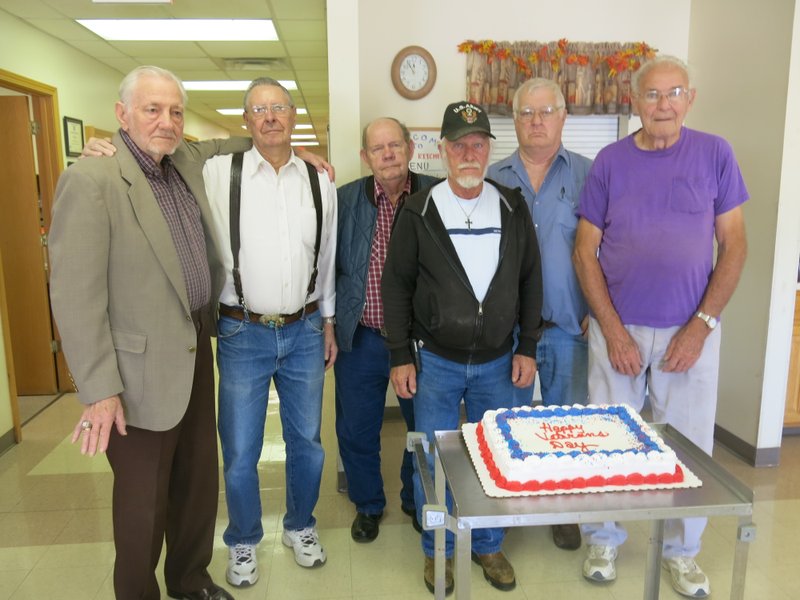 Photo by Susan Holland Guests for lunch at the Billy V. Hall Senior Activity and Wellness Center in Gravette on Monday enjoyed a Veteran&#8217;s Day program just preceding the meal. Each veteran present told a brief story about his experience in the military and all were given a small U.S. flag and a certificate in appreciation for their service. Ladies in attendance were given small red, white and blue lapel pins recognizing their family members&#8217; service. Shown with the cake inscribed &#8220;Happy Veteran&#8217;s Day&#8221; are Connie Mack Kays, Jack Kennedy, Leonard Allen, Ron Driskell, Forrest White and Henry Utecht.