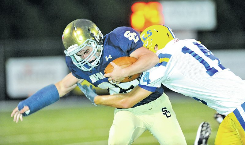 FILE PHOTO ANDY SHUPE Kyle Freeman of Shiloh Christian, left, carries the ball as Jacoby Hicks of Tulsa (Okla.) Victory Christian reaches to make the tackle during the first half of play Sept. 19 at Champions Stadium in Springdale. Freeman has battled through a rash of injuries, but suffered a knee injury last week that could mean the end to his season.