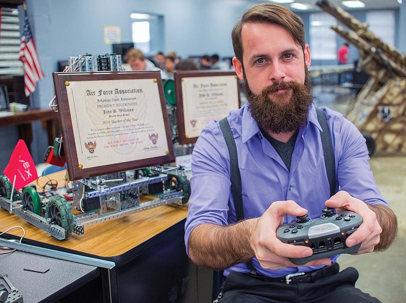 John Williams, engineering instructor at Bryant High School and Air Force Association 2014 High School Teacher of the Year for Arkansas, displays some of the school’s robots that have been in competitions. The robots are holding Williams’ recent awards.