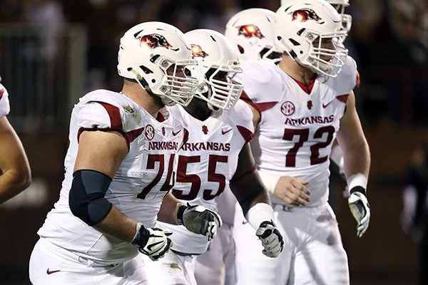 Arkansas guard Brey Cook (74), offensive lineman Denver Kirkland (55) and offensive tackle Frank Ragnow (72) prepare to drop into their stances against Mississippi State in the first half of an NCAA college football game in Starkville, Miss., Saturday, Nov. 1, 2014. No. 1 Mississippi State won 17-10. (AP Photo/Rogelio V. Solis)