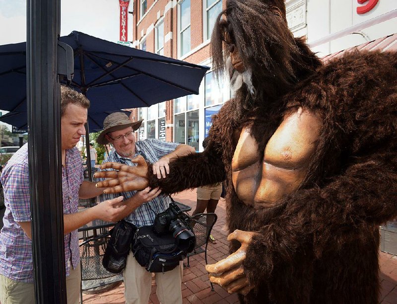 Bigfoot poses for a magazine photo shoot in downtown Bentonville earlier this year. A costumed actor played the part, stepping out to stroll the sidewalk.