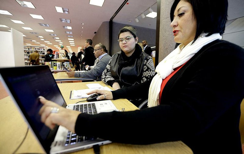 Outreach worker Leticia Chaw (right) helps Jennifer Sanchez with health insurance Friday in Houston. Community groups and advocates across the country are aiding the uninsured during the second round of open enrollment under the Patient Protection and Affordable Care Act. 