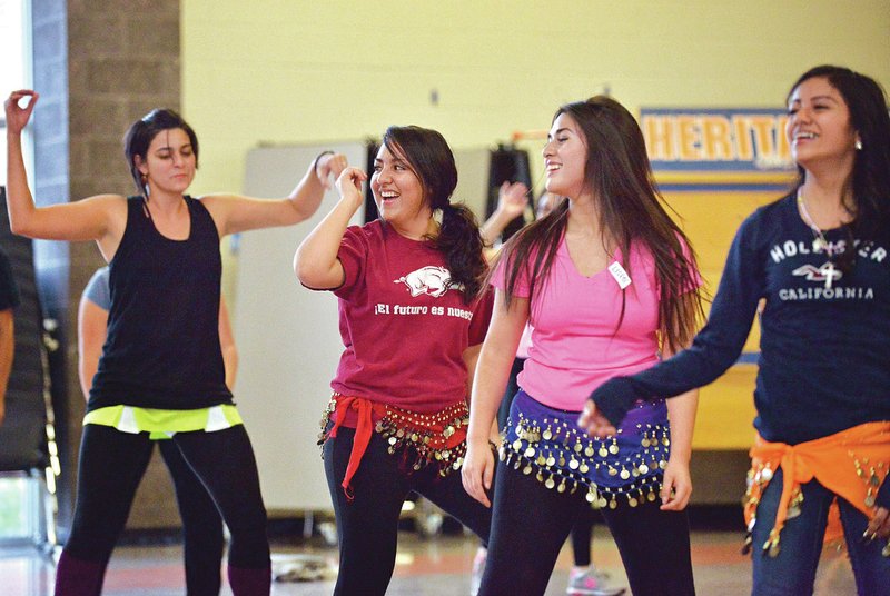 STAFF PHOTO BEN GOFF @NWABenGoff Cinthia Salas, 16, from left, Lisette Devora, 16, and Maria Bahena, 17, take part in a Zumba class Wednesday through the Girls with Goals program at Heritage High School in Rogers.