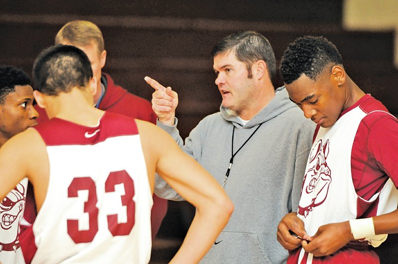  Staff Photo J.T. Wampler Brad Stamps, Springdale High basketball coach, discusses drills with his squad Thursday at the school.