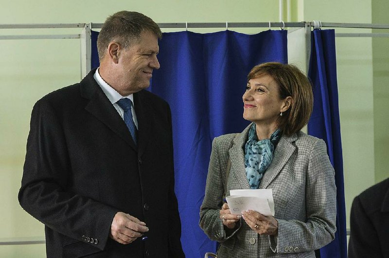 Klaus Iohannis, leader of Romania's center-right Liberals and mayor of the Transylvanian city of Sibiu, shares a smile with his wife, Carmen, after casting his vote in Sibiu, in the central Romanian Transylvania region, Sunday, Nov. 16, 2014. Romanians have begun voting in a presidential runoff between the prime minister who promises stability and a city mayor who says he will fight corruption. The winner will replace President Traian Basescu, who steps down after 10 years. (AP Photo/Andreea Alexandru, Mediafax) ROMANIA OUT