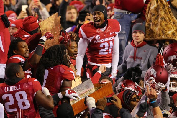 Arkansas players and fans celebrate with the boot on the field after shutting out LSU Saturday, Nov. 15, 2014, in Fayetteville.