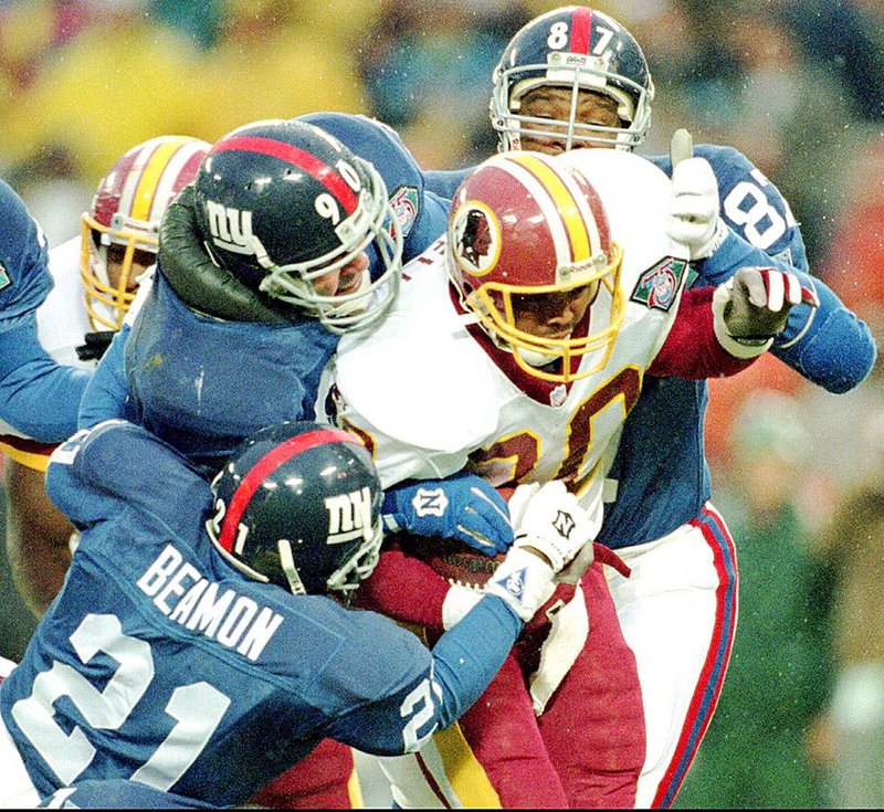 Redskins' fullback Brian Mitchell is swarmed by Giants' Willie Beamon (21), Corey Widmer (90) and Howard Cross (87) during first the quarter at RFK Stadium in Washington Sunday, Nov. 27, 1994. (AP Photo/Ted Mathias)