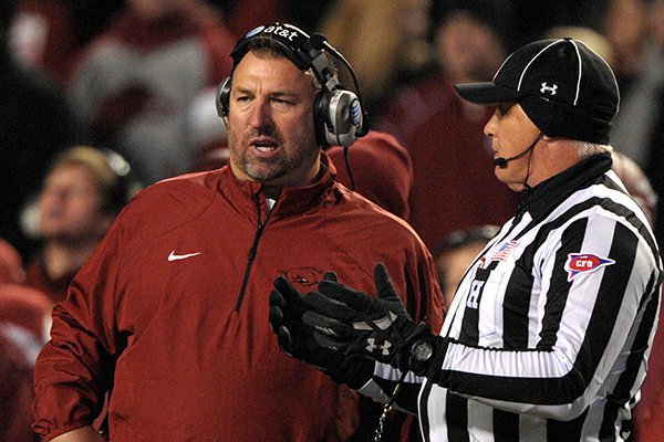 Arkansas cooach Bret Bielema, left, has a word with an official during the first half against LSU in an NCAA college football game in Fayetteville, Ark., Saturday, Nov. 15, 2014. (AP Photo/David Quinn)