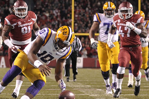 LSU quarterback Anthony Jennings (10) dives for a loose ball after a bad snap while Arkansas defensive tackle Darius Philon (91) and linebacker Martrell Spaight (47) close in during the first half of an NCAA college Football game in Fayetteville, Ark., Saturday, Nov. 15, 2014. LSU retained possession of the ball. (AP Photo/David Quinn)