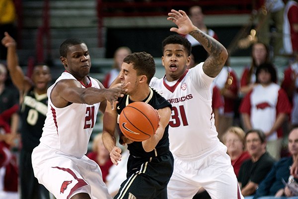 Wake Forest's Mitchell Wilbekin (10) is closely guarded by Arkansas defenders Manuale Watkins (21) and Anton Beard ( 31) during the first half of an NCAA college basketball game in Fayetteville, Ark., Wednesday, Nov. 19, 2014. (AP Photo/Sarah Bentham)